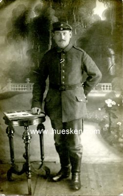 PHOTO 14x9cm: Feldgrauer Soldat stehend am Tisch.